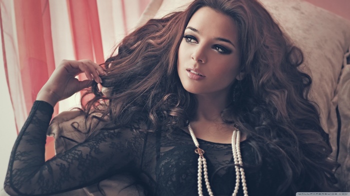 Cheryl Cole wearing a black lace top and pearl necklace