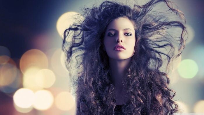 Woman with long curly hair and blue eyes