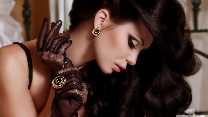 Woman with dark hair wearing lace gloves and jewelry