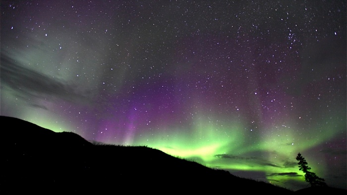 Aurora Borealis over a dark landscape in Norway