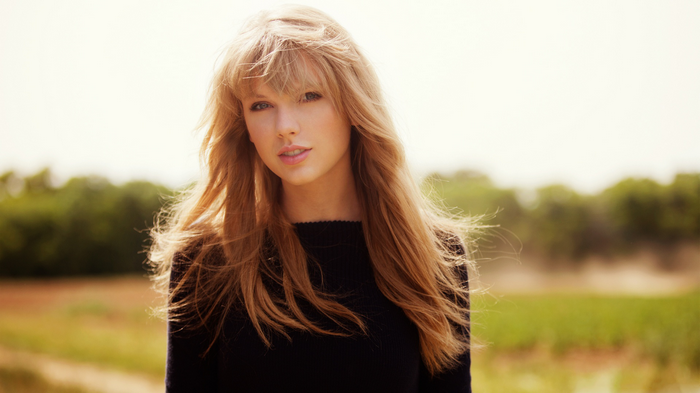 Taylor Swift in a black sweater outdoors