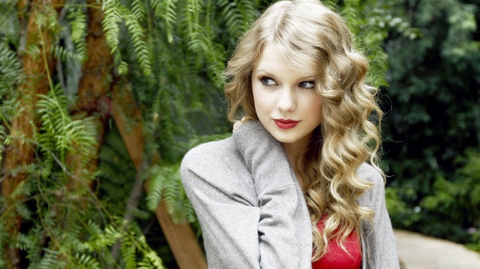 Taylor Swift with curly blonde hair outdoors