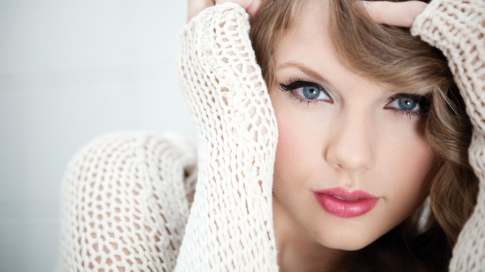 Taylor Swift wearing a white knitted sweater