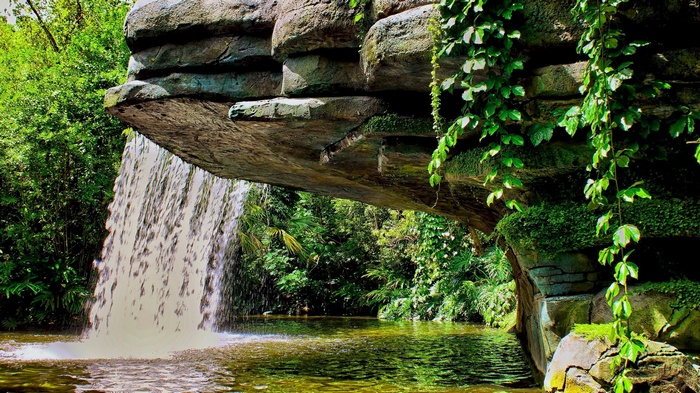 Waterfall cascading from rock formation into a pool
