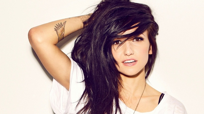 Valerie Poxleitner with long dark hair and a tattoo