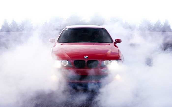 Red BMW E39 5 Series car in smoke