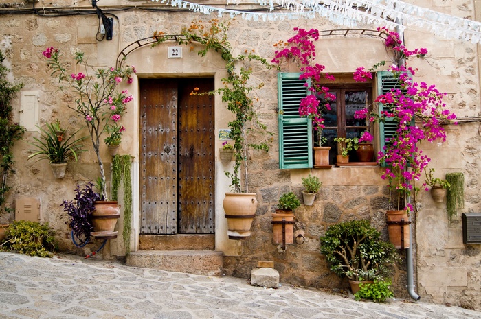 Stone house with wooden door and bougainvillea flowers