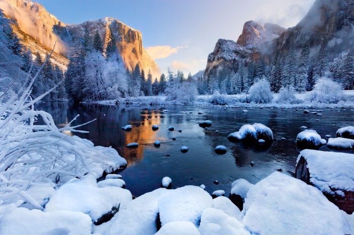 Winter scene in Yosemite National Park with snow-covered trees and a river