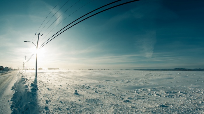 Winter landscape with power lines and sun