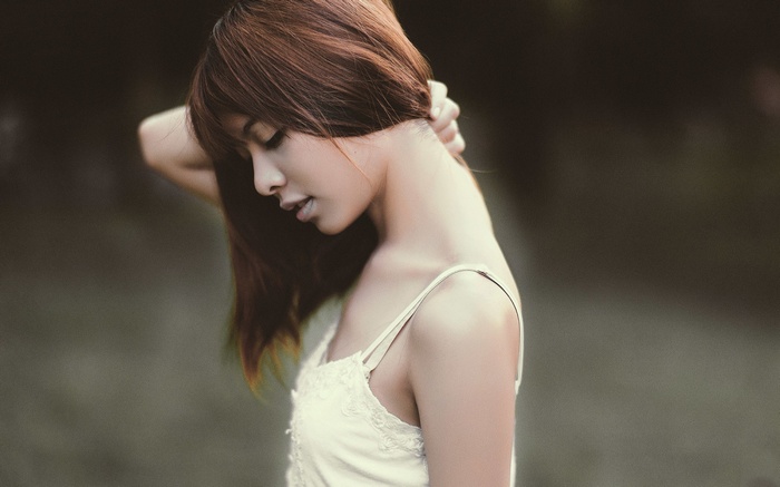 Asian woman with hand on neck