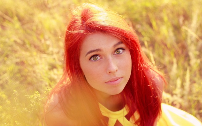 Redhead woman with green eyes in a field