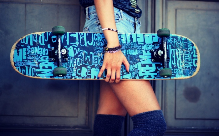 Woman holding a skateboard with graffiti design