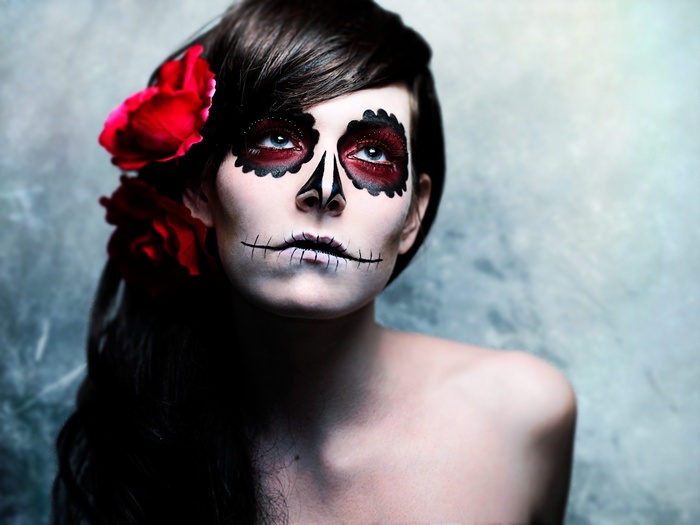 Woman with skull makeup and red roses