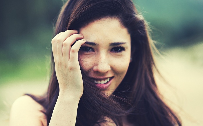 Young woman with freckles and brown hair smiling