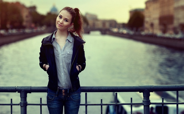Woman with ponytail in leather jacket by river
