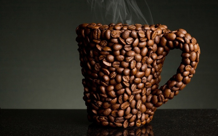 Cup made of coffee beans with steam