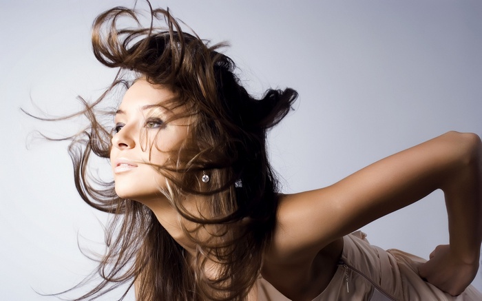 Woman with long brown hair blowing in the wind