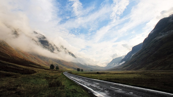 Road through a misty mountain valley landscape