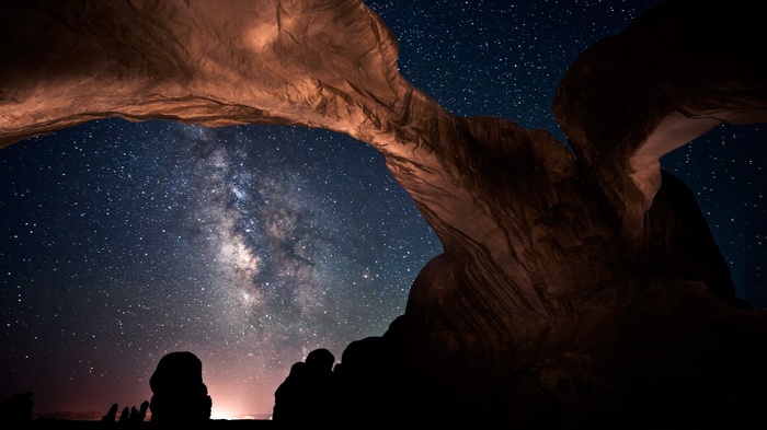 Milky Way galaxy seen through rock arches at night
