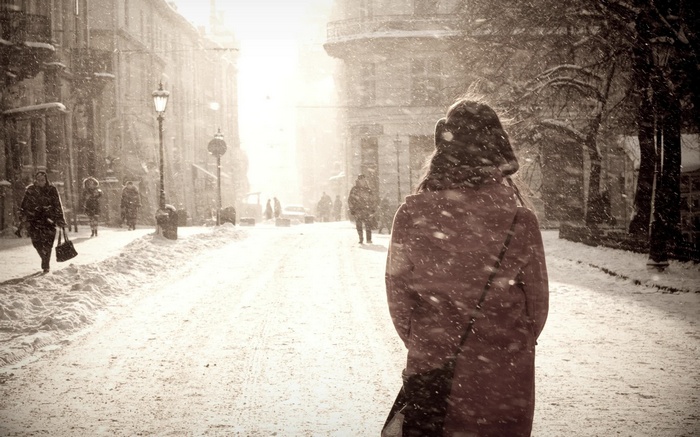 Woman walking in a snowy city street during winter