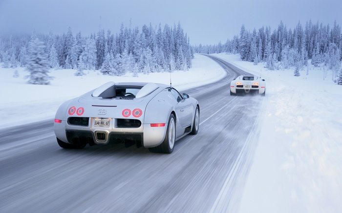 Two Bugatti Veyrons driving on a snowy road