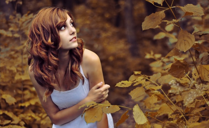 Woman with red hair in a white dress outdoors