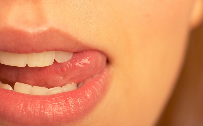 Close-up of a woman's mouth with tongue out