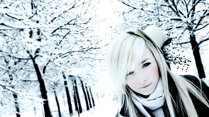 Woman with blonde hair and hat in the snow