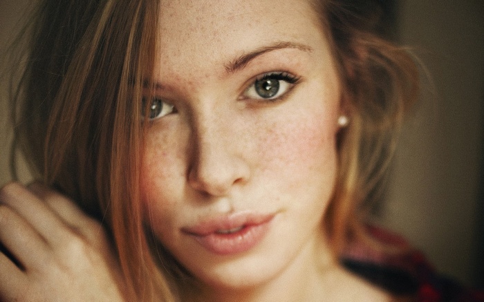 Close-up of a young woman with freckles and red hair