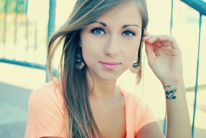 Woman with green eyes and a tattoo on her wrist