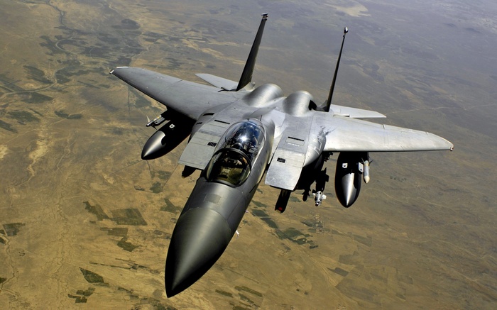 McDonnell Douglas F-15E Strike Eagle flying over desert terrain
