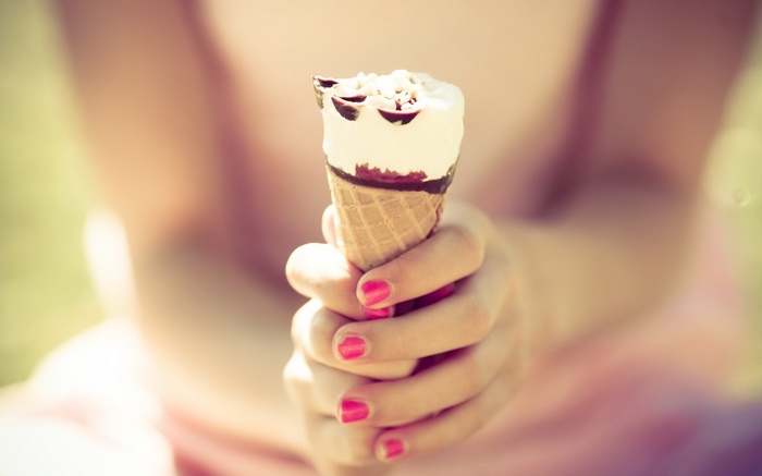 Woman holding an ice cream cone with painted nails
