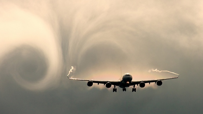 Airplane creating a large vortex in the sky