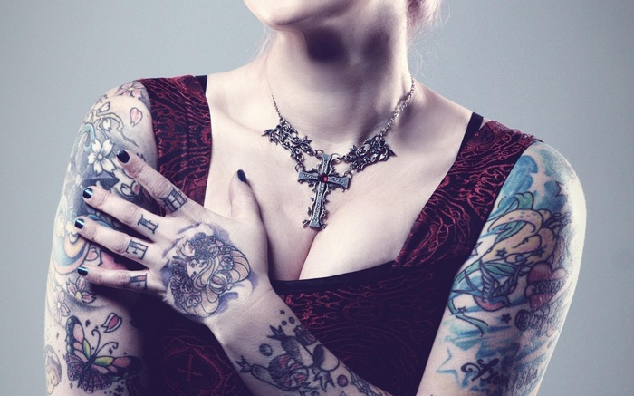 Woman with tattoos and a cross necklace