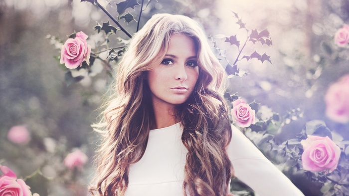 Woman with long curly hair and pink roses