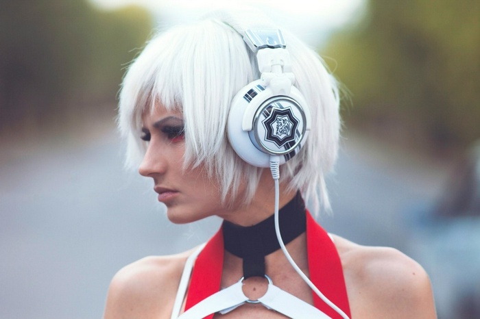 Woman with white hair wearing headphones and red outfit