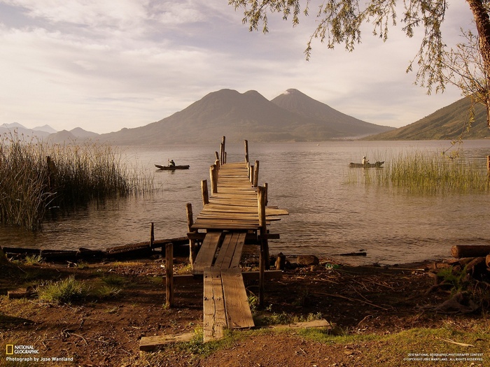 Wooden pier on Lake Atitlán with volcanoes in the background