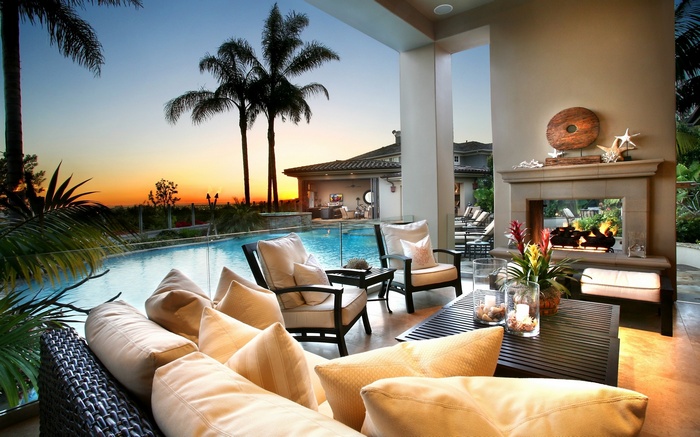 Luxury patio with swimming pool and fireplace at sunset