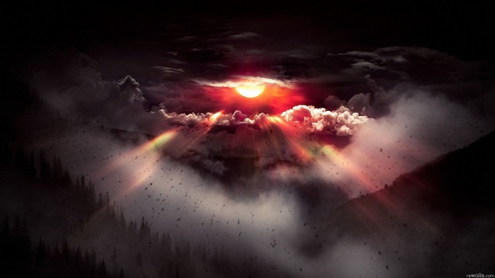 Sunlight breaking through clouds over a misty forest