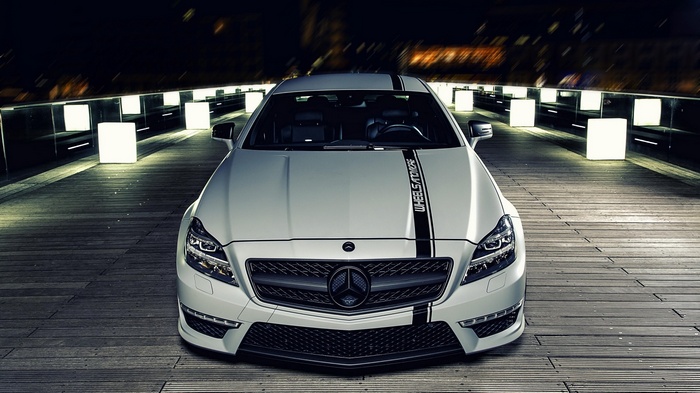 White Mercedes-Benz with racing stripes on wooden walkway