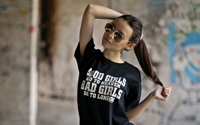 Woman wearing sunglasses and t-shirt with text