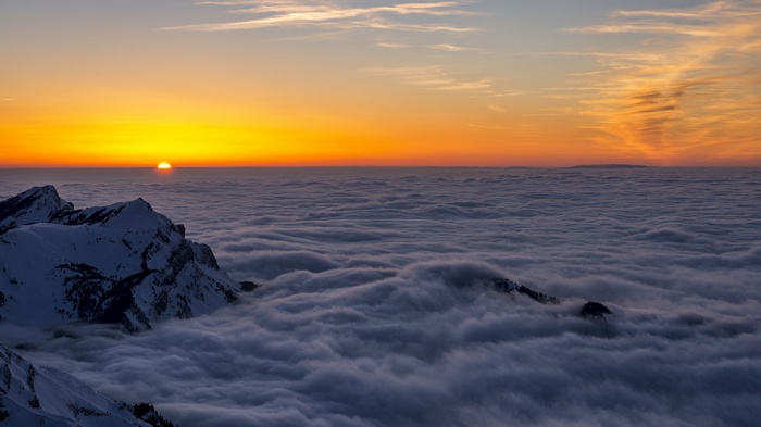 Sunrise over mountains above clouds