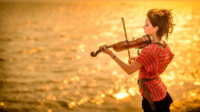Lindsey Stirling plays the violin at sunset