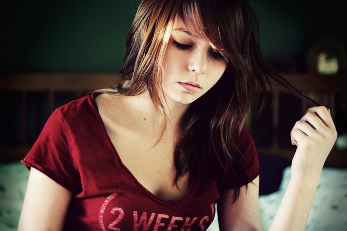 Young woman with brown hair wearing a red t-shirt