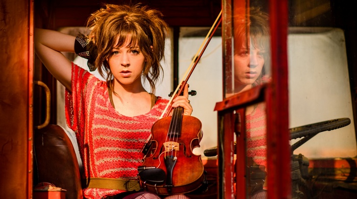 Lindsey Stirling with a violin in a vehicle