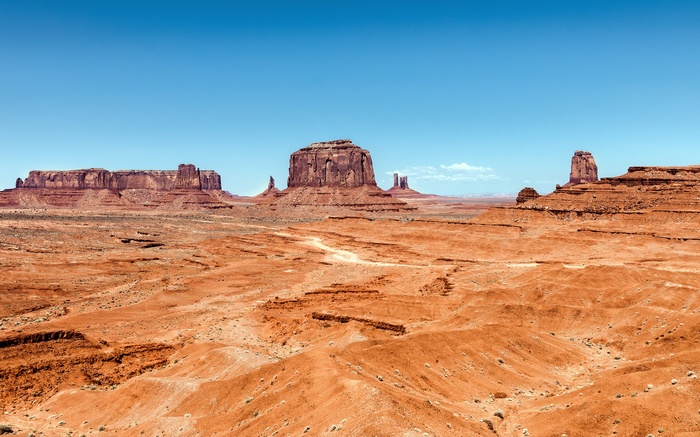 Monument Valley desert landscape with mesas under a blue sky