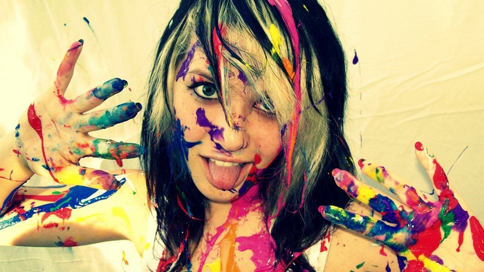 Woman with colorful paint on her face and hands