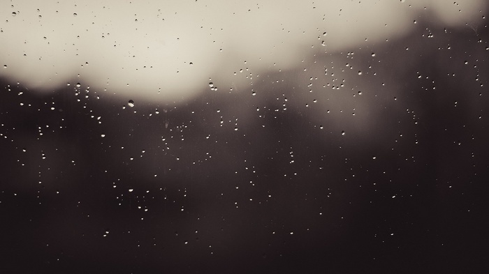 Monochrome image of water drops on glass