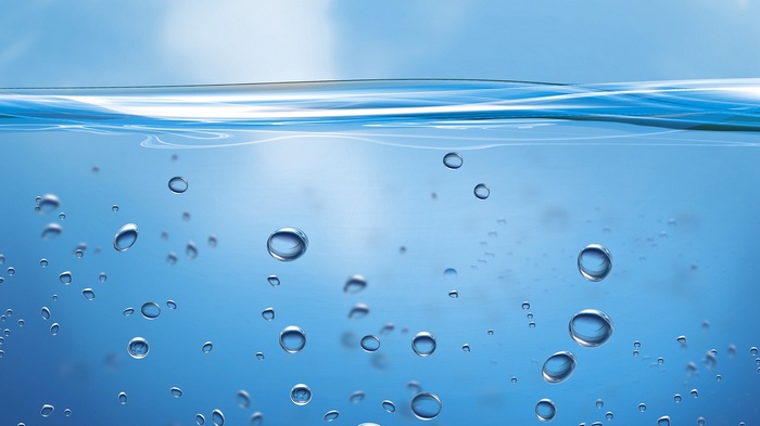 Bubbles in blue water with sky reflection