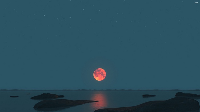 Red moon over the sea with rocks